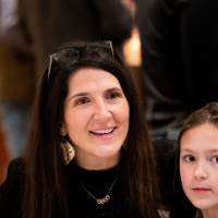 Woman sits next to child